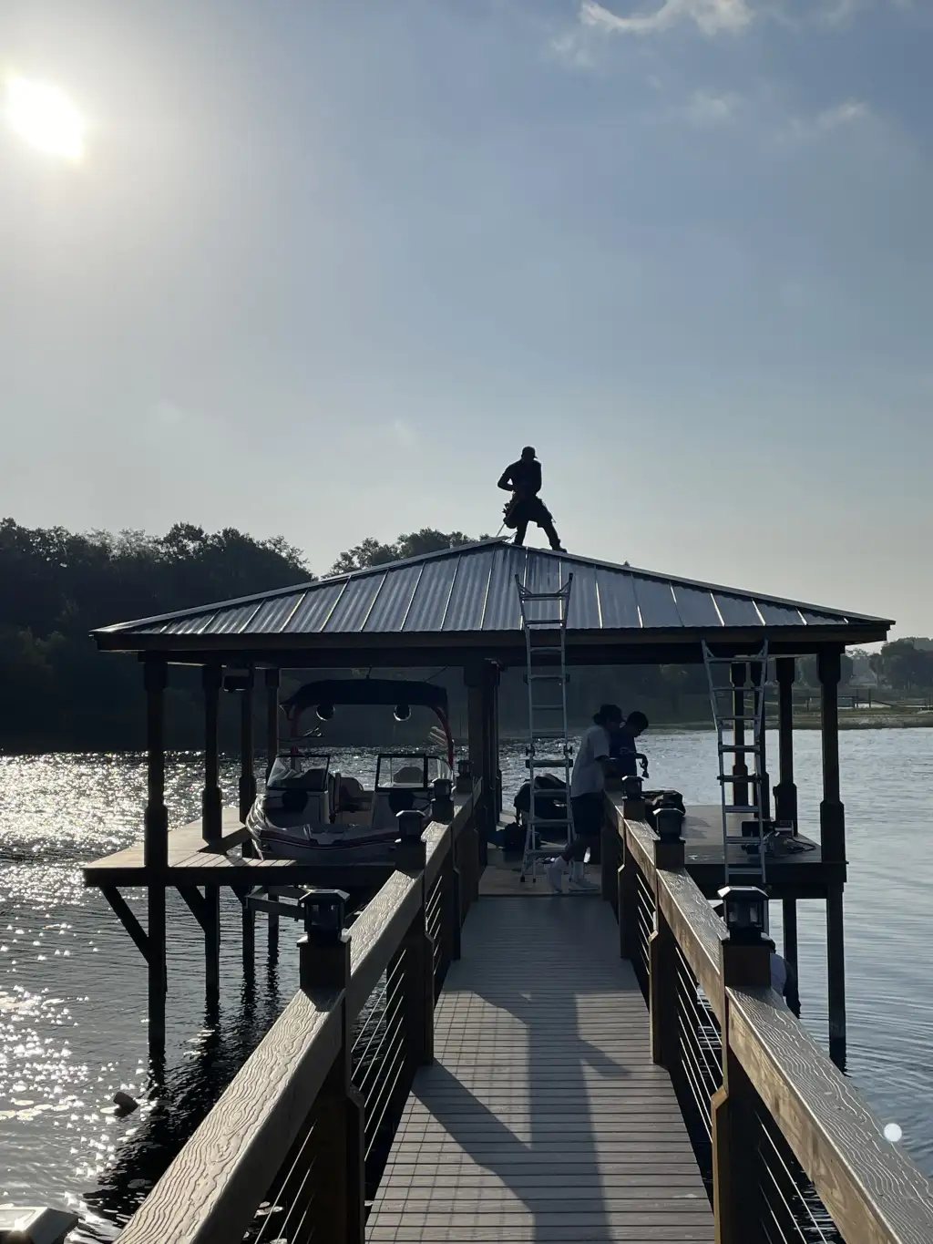EcoDocks crew working on a covered dock structure at sunrise