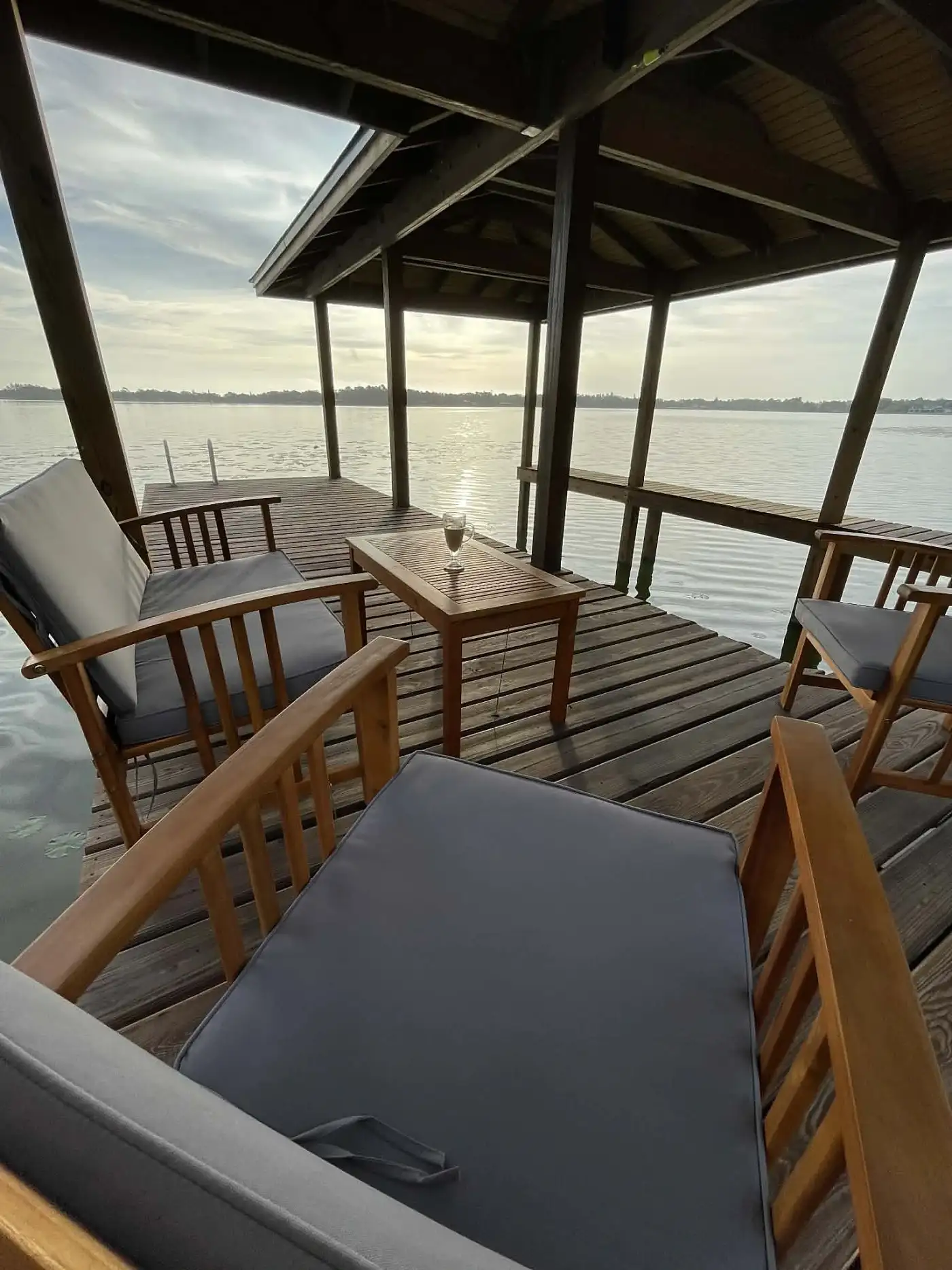 Covered dock lounge area overlooking the water at sunset